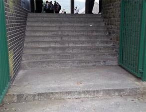 Uszkodzona powierzchnia schodów betonowych w szkole