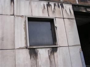 Pannelli in calcestruzzo con fessurazioni e delaminazioni di un edificio adibito a uffici