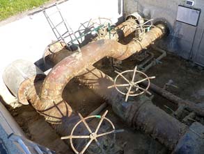 Corroded pipework in the access chamber of a district heating facility 