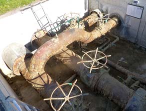 Corroded pipework in the access chamber of a district heating facility 