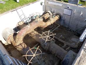 General view of corroded pipework in the access chamber of a district heating facility